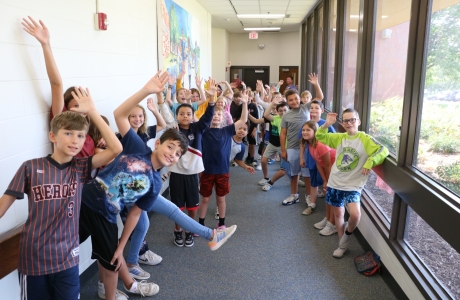 Kids in the hallway at Neihardt waving.