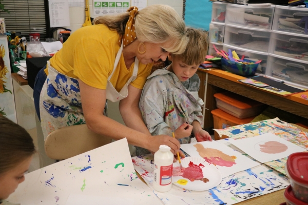 Teacher helping student with art