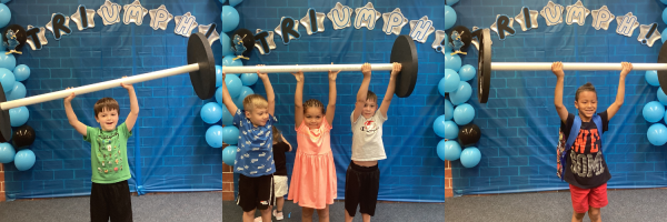 Students holding up weight bar in front of triumph sign