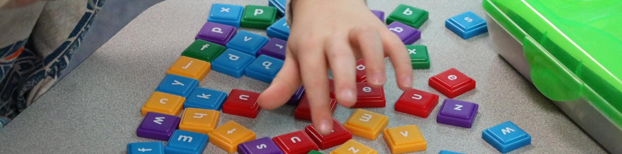student playing with letter tiles