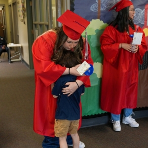 Graduate hugs sibbling
